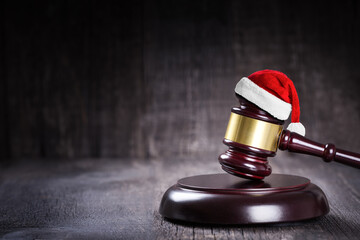 Santa Claus Hat on wooden judge gavel closeup on rustic background. Closeup. Christmas and New Year...