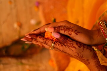 Close-up shot of the Bengali bride&rsquo;s mehendi hands during the wedding ritual