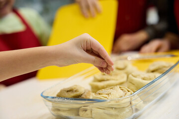 Kids making homemade cinnamon buns in kitchen