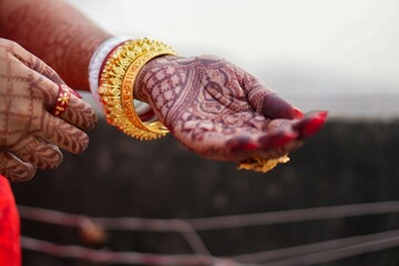 Bengali bride&rsquo;s mehndi hand with shankha pola and gold bangles