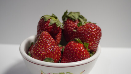 Strawberries in a small bowl on a white background. Strawberries Isolated on white.