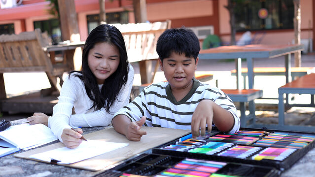 Asian Children Drawing Together Outdoors with Art Supplies and Color Set