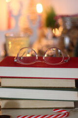 Cookie jar, tea, wine, nuts, books, lit candles and Christmas decorations on the table. Cozy Christmas hygge at home. Selective focus.