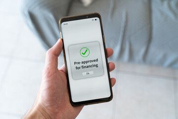 Pre-approved for financing message on phone screen. Concept of online banking.