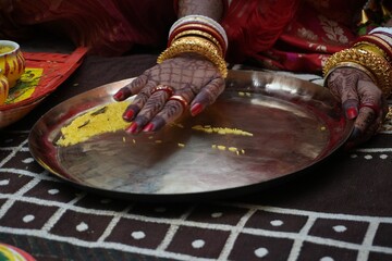 Bengali wedding ritual with yellow rice on brass plate