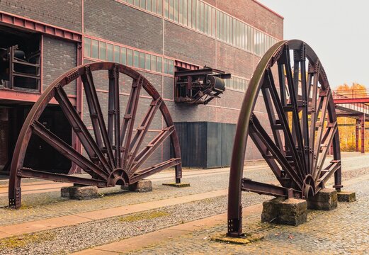 Halved winding wheels of a former coal winding tower in a disused industrial area