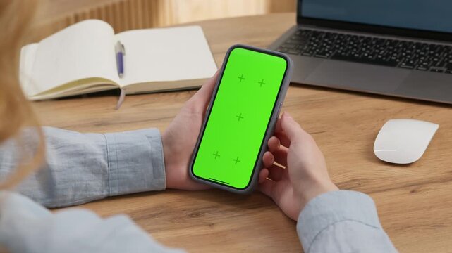 Woman use digital tech cell phone green screen mock up talk video call. Hand press click phone web site middle center. Girl hold mobile. Chroma key page. Cozy home background. Online app copy space.