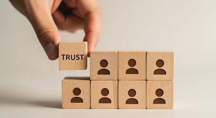 Building trust in a team hand placing a trust block on top of team member blocks for strong leadership