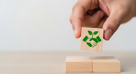 Hand placing wooden block with recycle symbol on top of other blocks sustainable future and environmental awareness concept