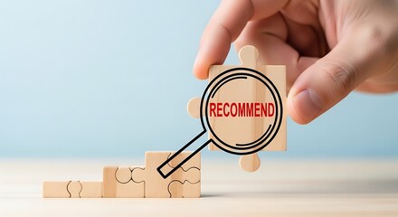 Magnifying glass focuses on recovery on wooden blocks representing progress and healing with hand holding the magnifier