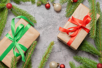 Christmas composition. Gift boxes, fir tree branches, red and gold decorations on grey background. High quality photo