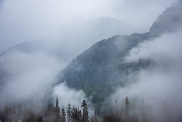 Serene Landscape of cloud shrouded mountains of Pir panjal range near Atal Tunnel in Manali of Himachal Pradesh, India.
