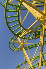 Green and yellow carousel tracks against a blue sky