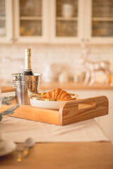 Festive breakfast with croissant and champagne in a cozy kitchen