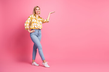 Young woman in casual fashion posing on pink background showcasing style and happiness