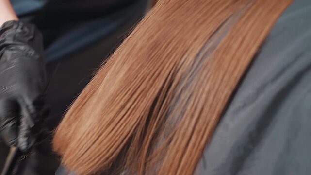 professional stylist trims split ends, caucasian hairstylist meticulously cuts split ends with tools, closeup shot capturing stylist carefully trimming split ends on smooth brown hair strands