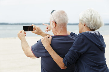 an aged couple travels with their phone