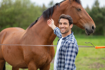 happy man next to horse at fence