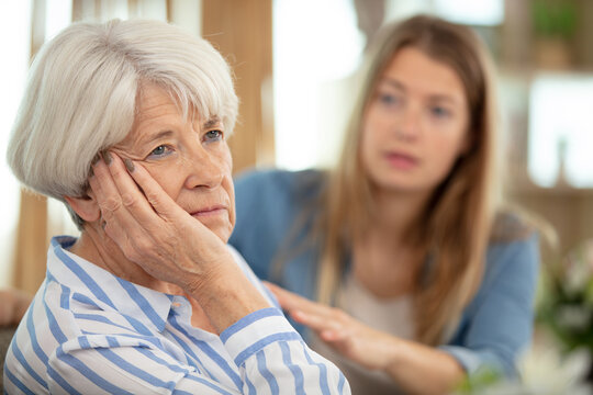 young adult woman consoles sad senior adult female