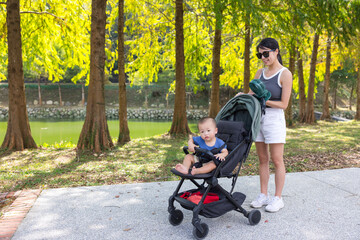 Mother strolling with baby stroller along Sun Moon Lake path