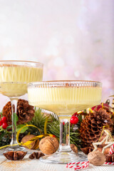 Traditional Christmas Eggnog Martini Or Brandy Alexander Cocktail with cinnamon and nutmeg, with golden Christmas decorations and bokeh effect, copy space