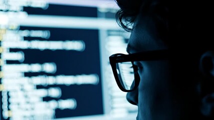 Focused programmer coding on a computer screen working late at night developing software and cybersecurity solutions 4K Video - Powered by Adobe