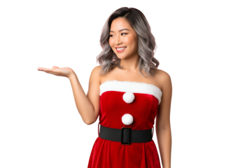 Smiling young asian woman wearing a strapless red and white santa claus costume holding out her hand to present something, isolated on transparent background