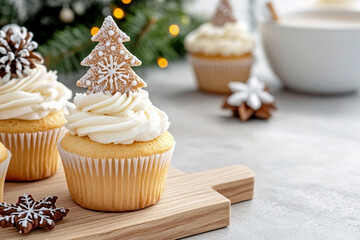 Vanilla christmas cupcake with white cream frosting topped with a gingerbread tree cookie and chocolate snowflake on a small wooden board. Concept of traditional holiday baking and elegant treat