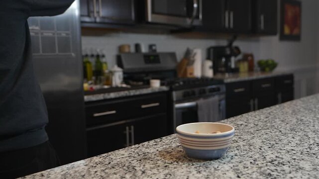 slow-motion pouring homemade kefir into breakfast cereal