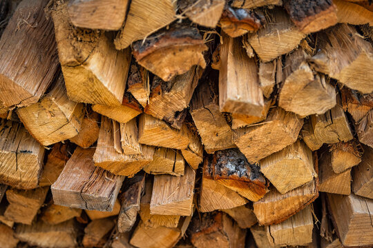 Stack of winter firewood logs macro closeup for fireplace burning in ski resort provided by Homeowner Association with pattern of wood