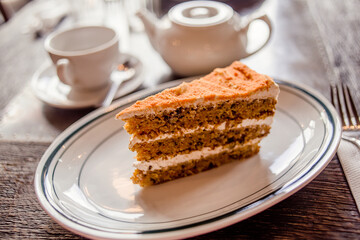Tea time in a café with carrot cake on a wooden table
