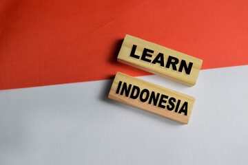 Learn Indonesia text stacked wooden cubes and Indonesia flag background.