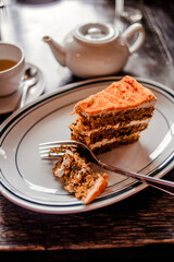 Tea time in a café with carrot cake on a wooden table