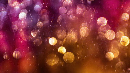 Abstract image featuring vibrant, sparkling bokeh lights. Glowing circles in pink, purple, and orange create a magical, festive, and ethereal background.