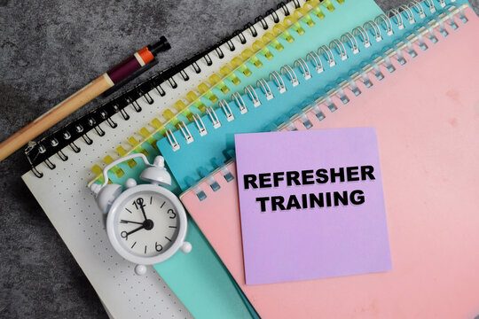 Concept of refresher training write on sticky notes isolated on Wooden Table.