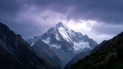 Majestic snow capped mountain peak at dusk under dramatic stormy clouds