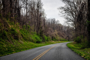 Car point of view driving in Blue Ridge mountains parkway forest in Virginia with paved asphalt road and cloudy overcast sky