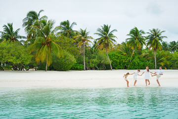 Young family on vacation have a lot of fun on the beach. Family trip to Stand.