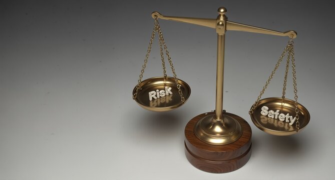 balancing risk and safety on vintage scales with word reflections, concept for decision making and liability.