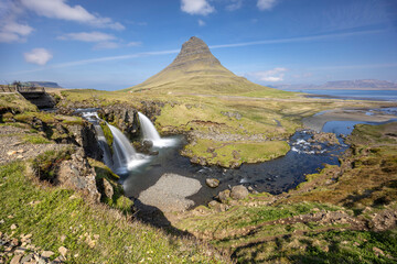 long exposure capture of Mount Kirkjufell and the waterfall Kirkjufellsfoss on a sunny day, Snaefellsnes Peninsula, West Iceland