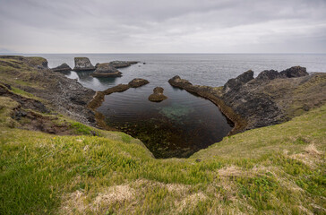 unique oval shape rock formation, cliffs and sea stacks along the coastal path at Arnarstapi, Sn&aelig;fellsnes Peninsula, Iceland