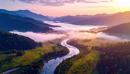 Aerial view of a river winding through a valley surrounded by mountains, with morning fog and a colorful sunrise.