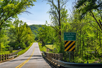South Fork Rockfish river sign by road bridge in Nelson county valley, Virginia in green sunny summer by rural countryside farm