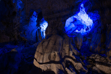 Mysterious Cave Interior With Blue Light Openings Resembling Demon Eyes