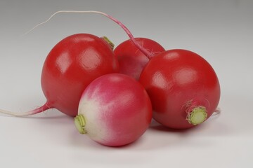 Fresh red radishes with green leaves isolated on white background