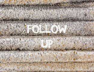 Follow up symbol. Concept word Follow up on beautiful grey mountain wall. Beautiful grey mountain wall background. Business follow up concept. Copy space.