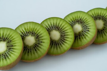 Freshly sliced kiwi fruits in a row isolated on white background