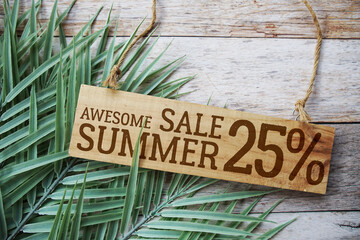 Awesome Summer Sale 25% off with green leaf on wooden background