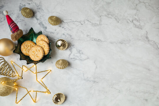 galletas en recipiente con forma de hoja sobre superficie de mármol con estrella y decoracion de navidad - Powered by Adobe