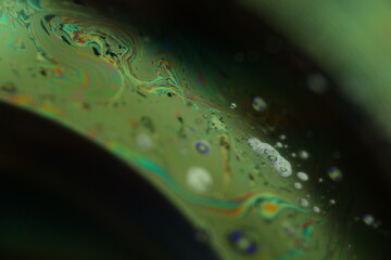 Green liquid chemical surface, phenomenal structure, green oils on a dark background, colourful abstract, surrealistic art, iridescent effect